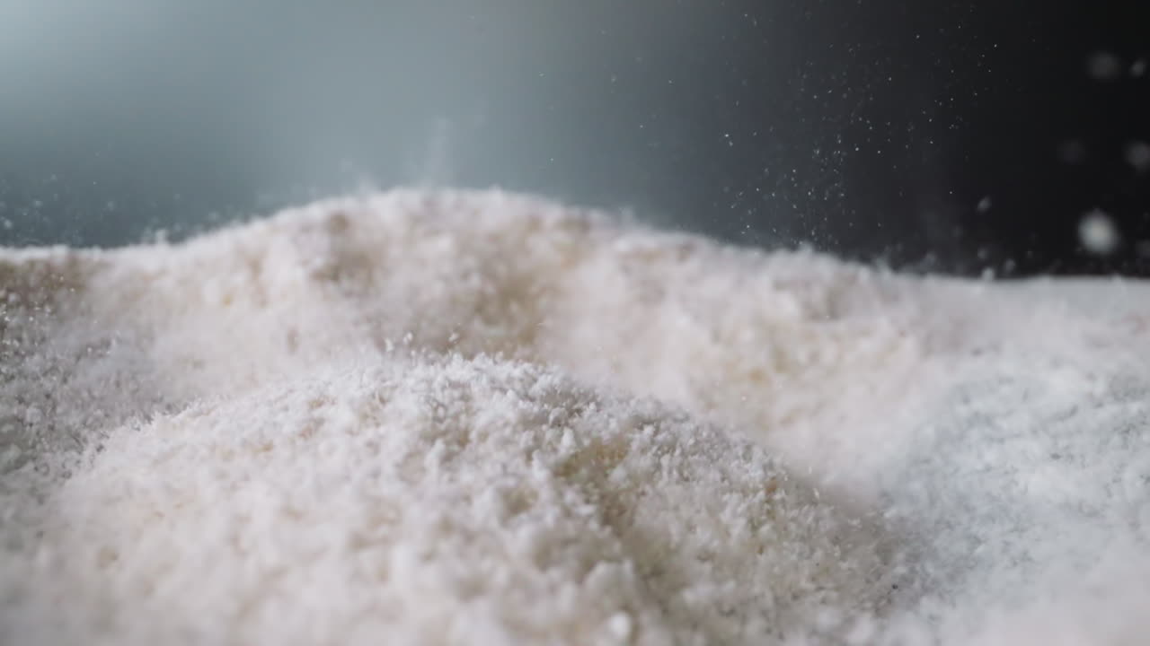 Coke powder bounces on concave surface against grey wall