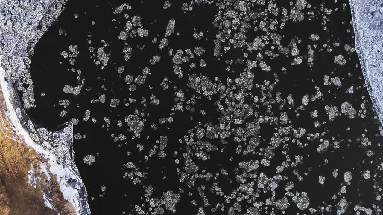 Flowing ice pieces in river, aerial top down view