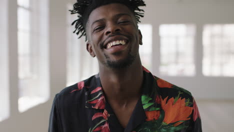 slow motion portrait of relaxed african american man laughing happy looking at camera enjoying lifestyle change wearing hawaiian shirt in new apartment