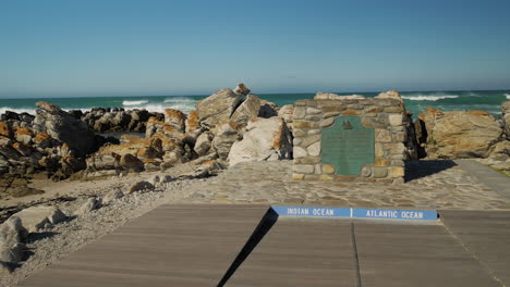 Punto-De-Referencia-En-L&#39;agulhas-Que-Muestra-El-Punto-Más-Meridional-De-África,-Donde-Se-Encuentran-El-Océano-índico-Y-El-Atlántico,-Toma-Panorámica