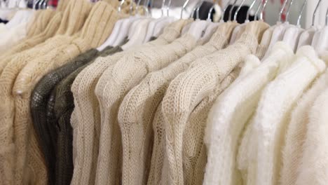 close-up of a rack of cream and white sweaters