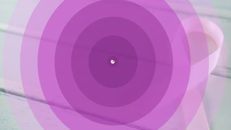 animation of purple circles and hope with pink ribbon over ribbon on white wooden background