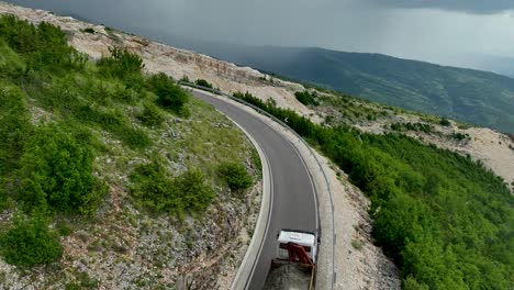 lorry carrying cement and emitting black smoke up a small mountain road