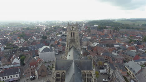 Volando-Sobre-La-Basílica-De-Nuestra-Señora-Hacia-Su-Torre-Del-Reloj-En-Tongeren,-Bélgica