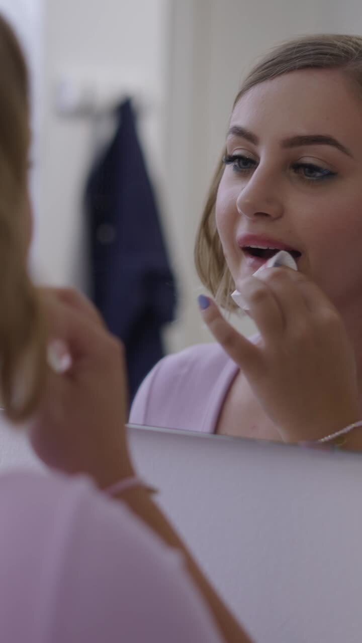 Woman Applying Makeup in Mirror