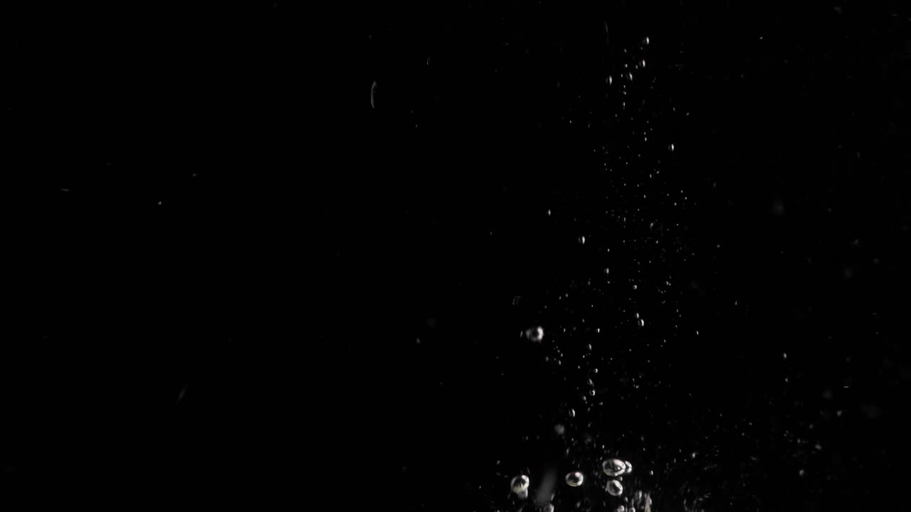 kiwi cayendo al agua en cámara superlenta, fondo negro, muchas burbujas de aire, 4k240fps