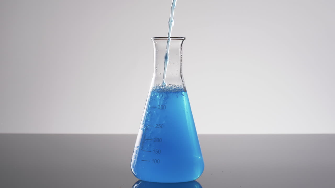 video de vaso de laboratorio de vidrio con líquido azul con espacio de copia en fondo blanco