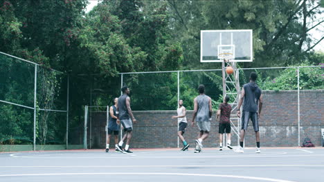 group of men playing basketball outdoors