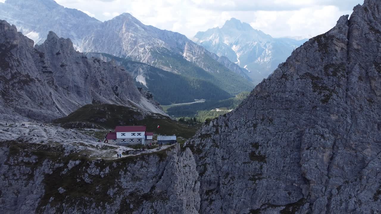 imágenes en 4k de un dron volando lentamente desde una casa muy encantadora ubicada en medio de las impresionantes formaciones rocosas y montañas de los dolomitas en el tirol del sur en italia