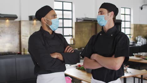 caucasian and mixed race chefs wearing masks