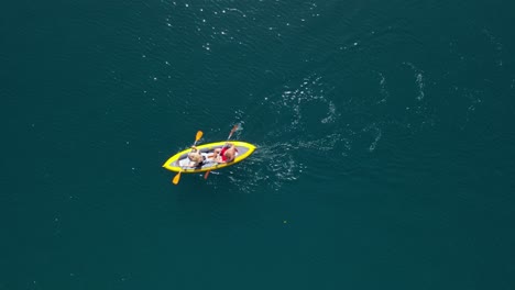 Antena-De-Primer-Plano-De-Un-Kayak-De-Mar-Amarillo-Con-2-Personas-Remando-Juntas