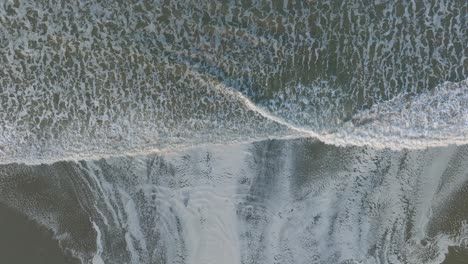 aerial top down drone shot of high tide rivers at pismo beach california at sunrise