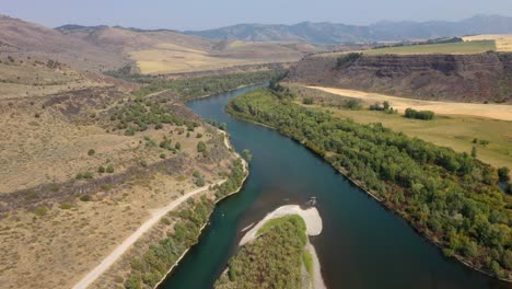 Río-Sinuoso-En-Idaho-Con-Paisaje-De-Montaña-Y-árboles-Verdes-Y-Exuberantes-En-Verano