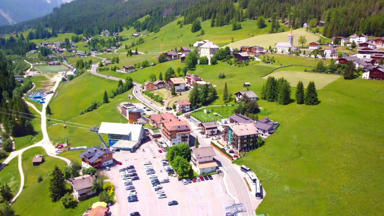 Aerial shot of La Villa village in South Tyrol, Italy, showing stunning mountains and picturesque green landscapes