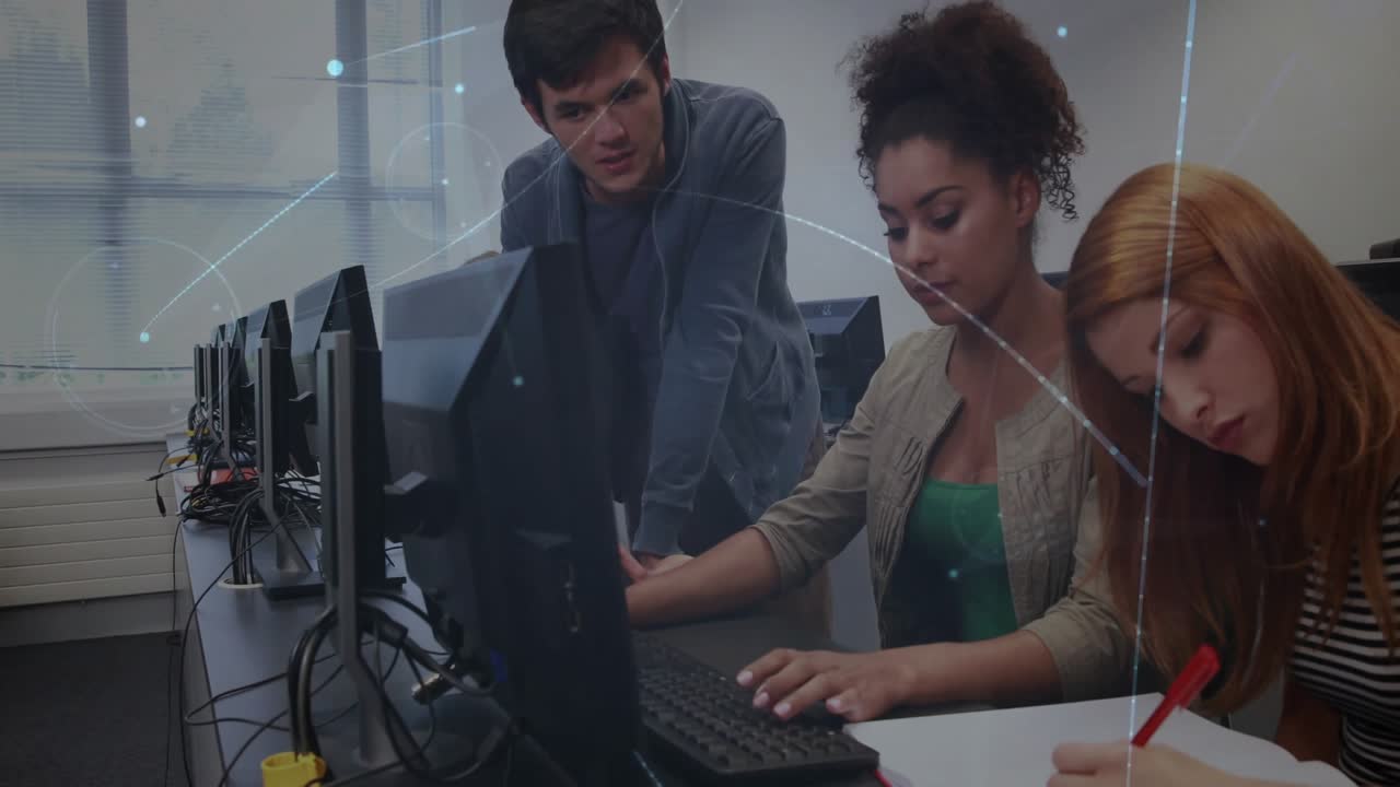 Peer student pointing at screen, guiding pair coding and notes in computer lab via network graphics