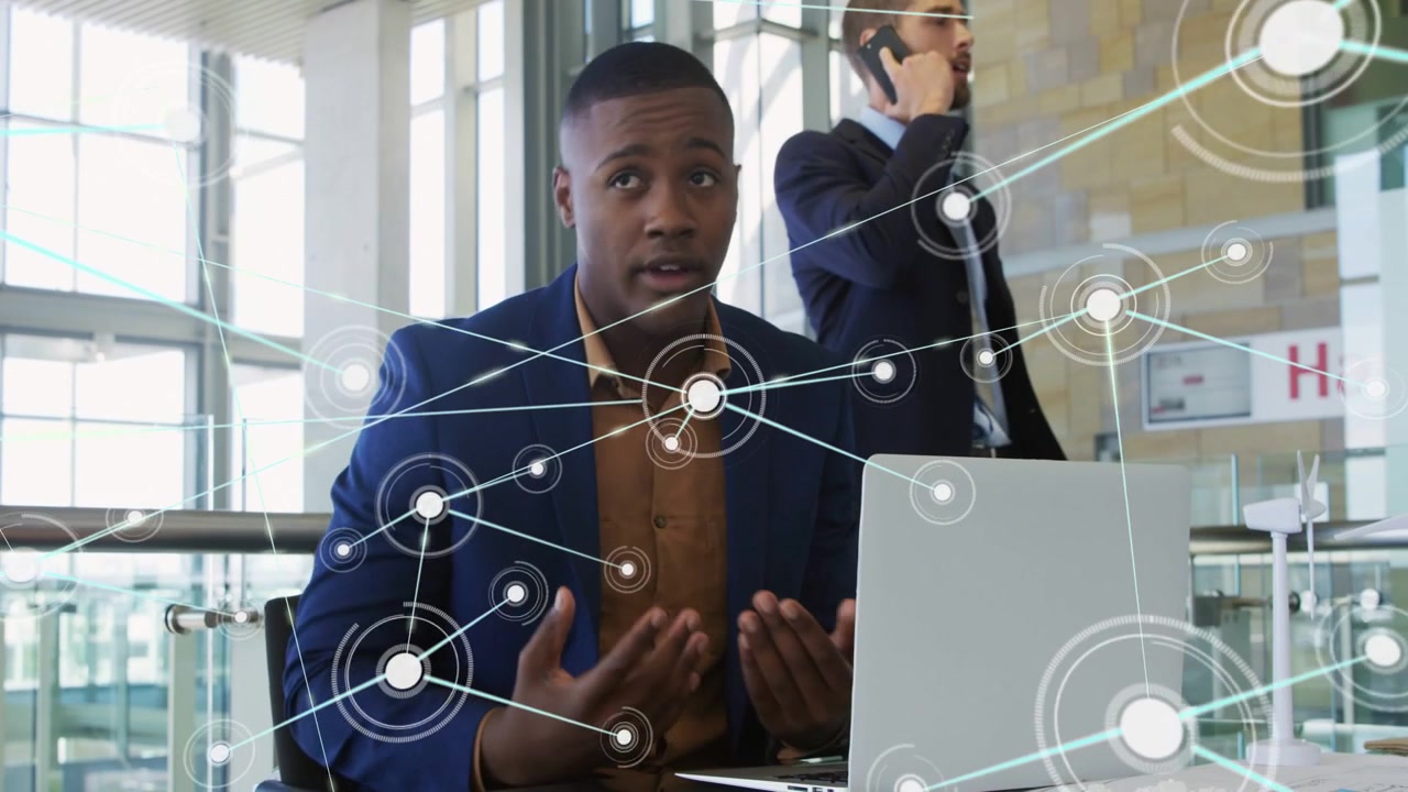 Seated man touching laptop keys, typing in atrium, animated nodes expanding showing business data