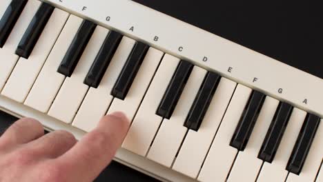 finger pressing notes on a piano