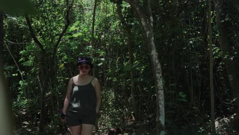 mujer explorando un bosque durante una mañana soleada y brillante