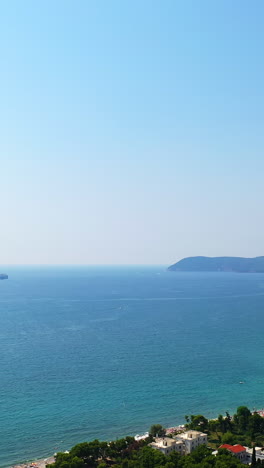 coast of the adriatic sea in the city of bar, montenegro. picturesque view of the urban terrain on the slopes of gorgeous green mountains. aerial view. vertical video