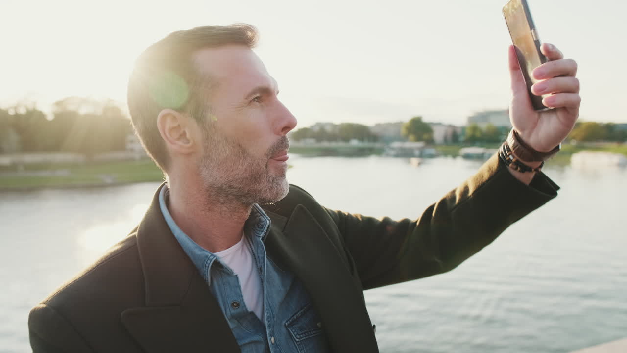 Man taking a selfie outdoors near a river