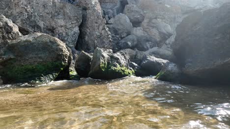 rocky coastline with mossy boulders and water