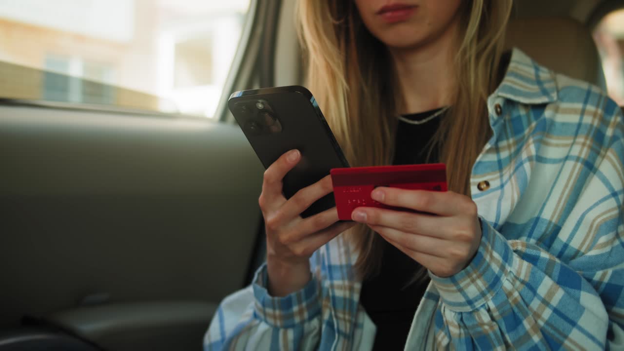 mujer pagando con teléfono móvil y tarjeta de crédito en el coche