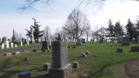 4k: driving slowly by rows of old headstones through a cemetery on a beautiful day