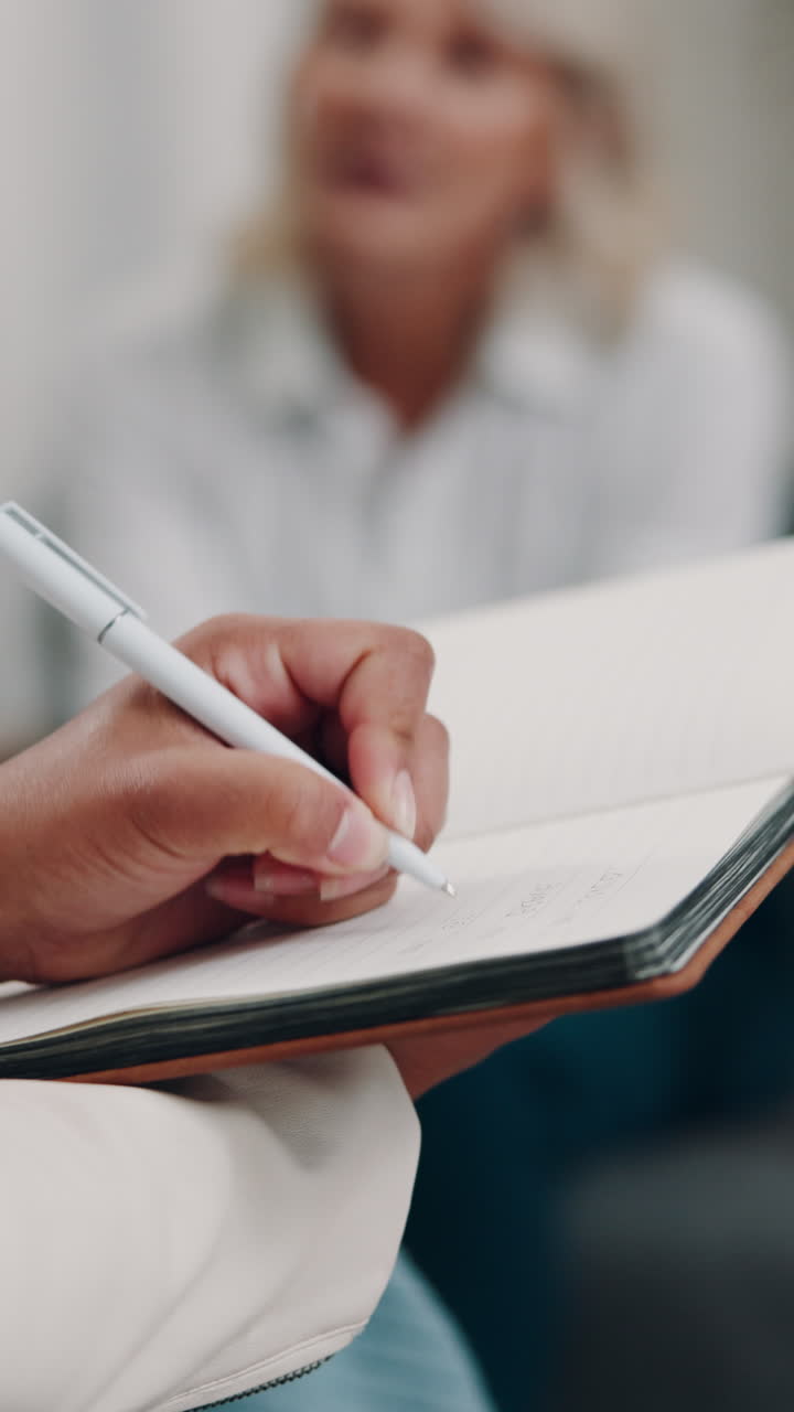 Close-up of Hand Writing Notes in a Notebook