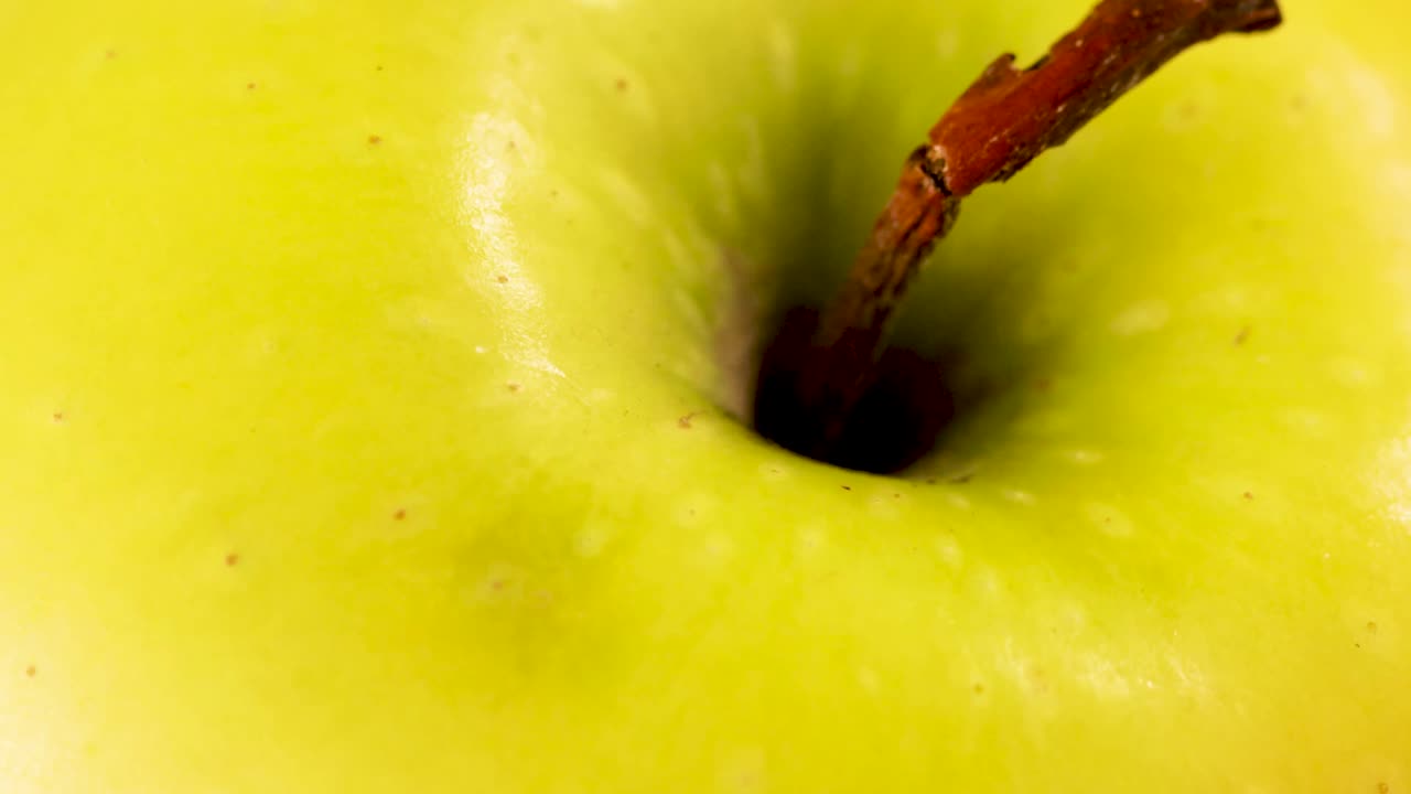 Product shot of a green apple with broken stem