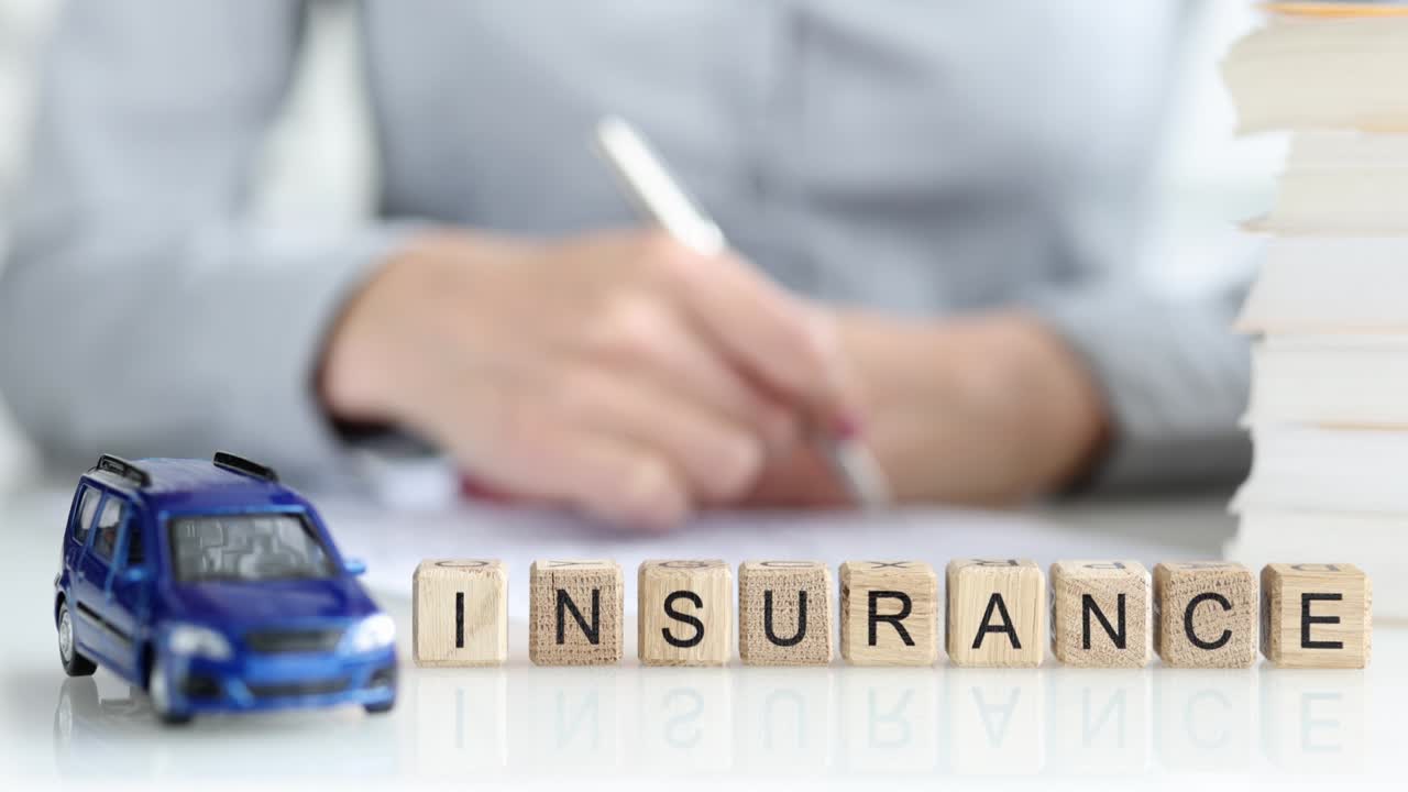 Insurance agent fills out car insurance contract closeup