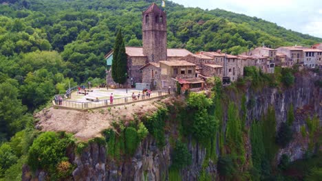 Volando-Lejos-De-Una-Iglesia,-Y-El-Punto-De-Vista-En-Castellfollit-De-La-Roca,-Pueblo-Típico-De-Cataluña,-España