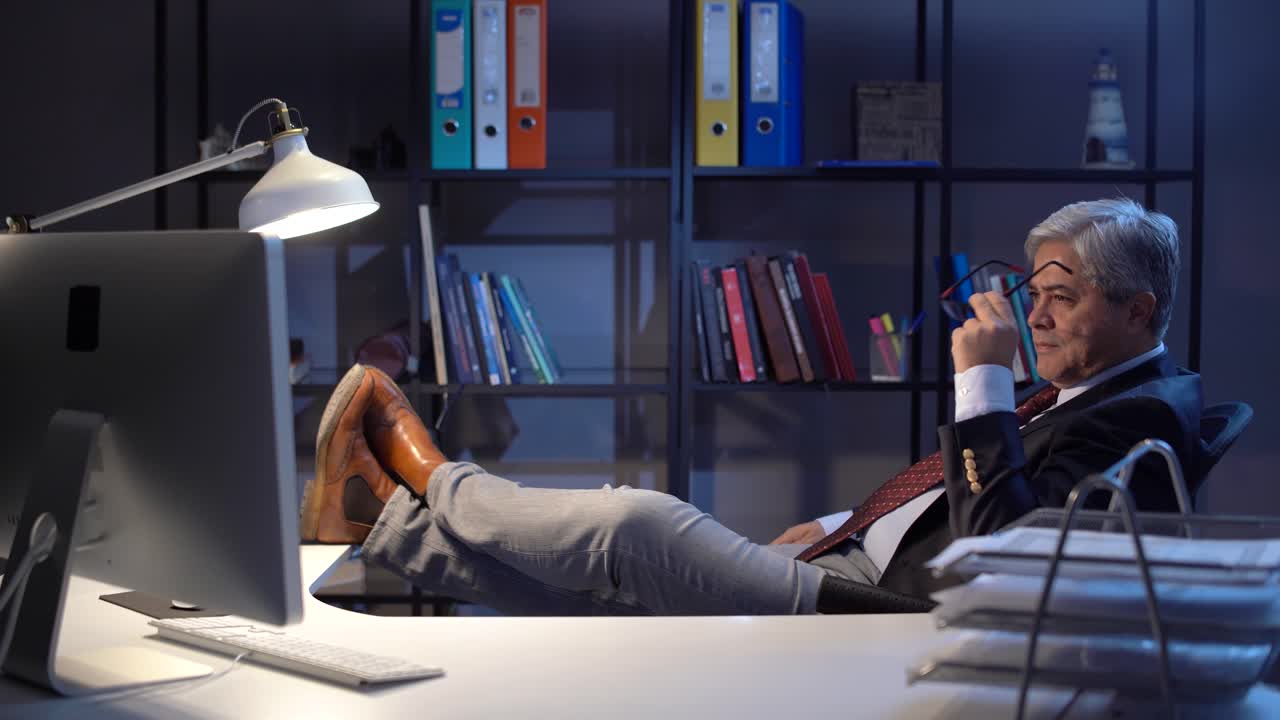 테이블 위에 발을  ⁇ 고 있는 사려 깊은 임원입니다.