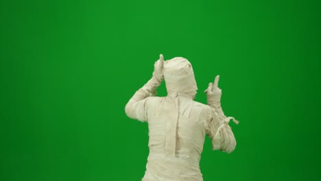 scary mummy wrapped in bandages dances wearing a black hat and sunglasses green screen isolated