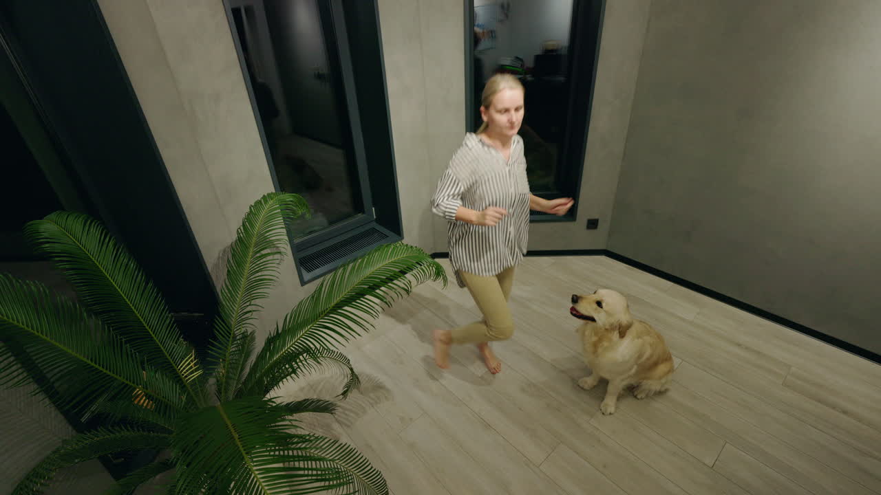 женщина танцует с собакой дома.