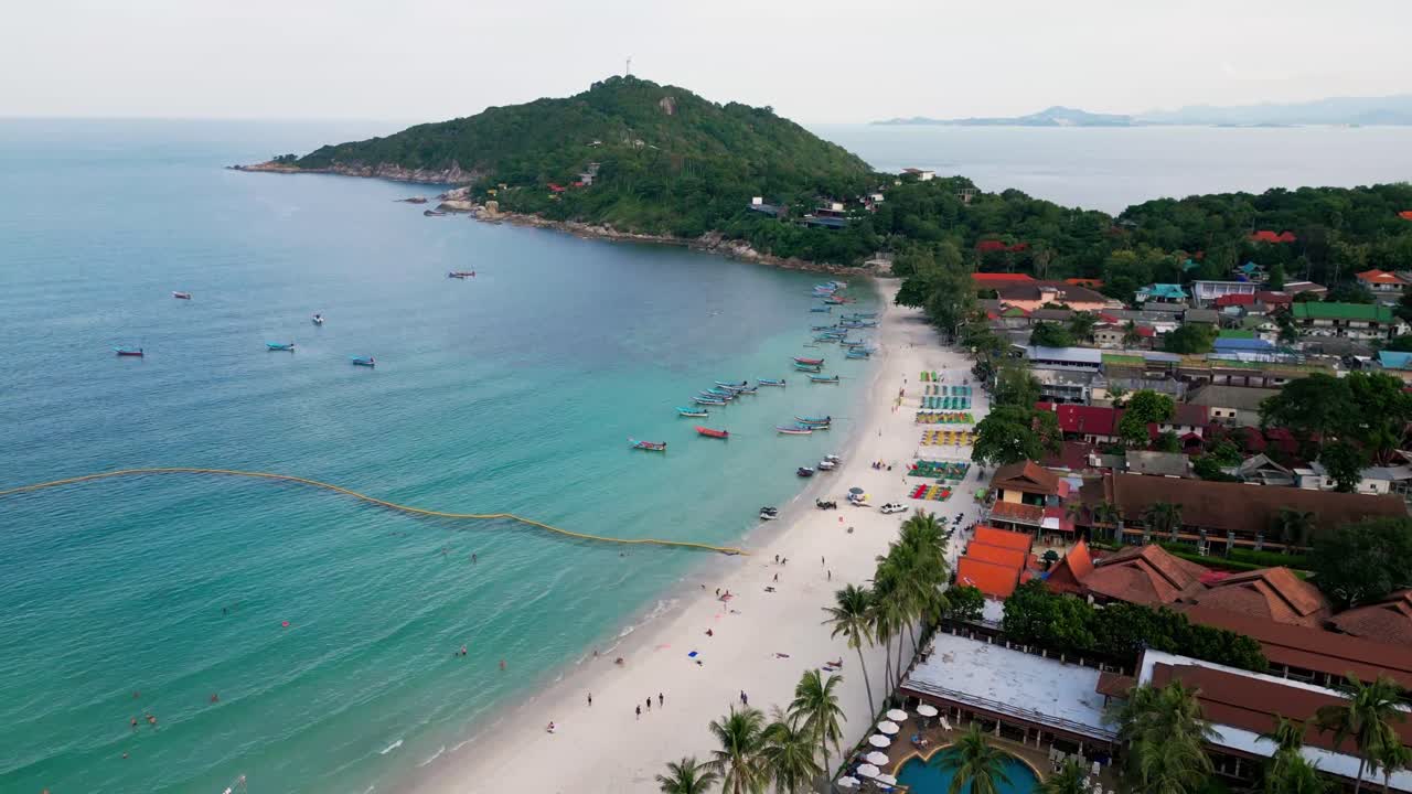 Aerial Fly White sand beach at Haad Rin Koh Pha Ngan Thailand travel destination waterfront hotels and palm trees