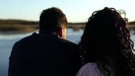 slow motion-back view of romantic engaged couple looking at pond