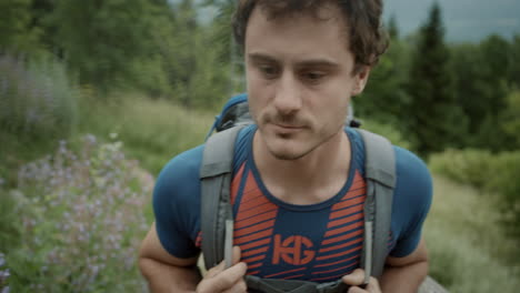 close up of a young hiker walking up a narrow road towards the peak of a mountain