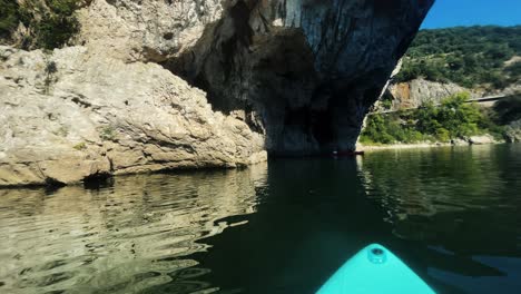 Couple-kayaking-on-river-in-front-of-beautiful-cliffs-in-Ardeche-filmed-from-stand-up-paddle-board