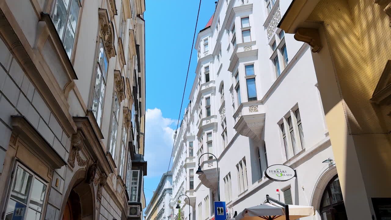 Vienna, Austria - June 9, 2025: A walk by the narrow street among the beautiful old-fashioned building. Spectacular architecture with lanterns on the facades in Vienna, Austria