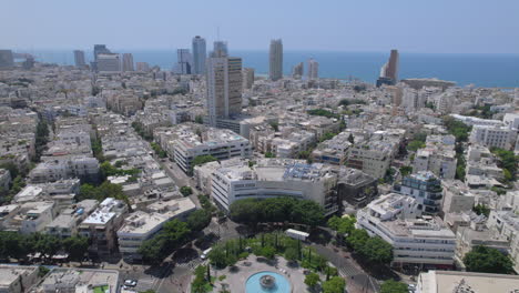 revealing dizengoff square on a very hot day without people and activity near the fountain - pull back shot