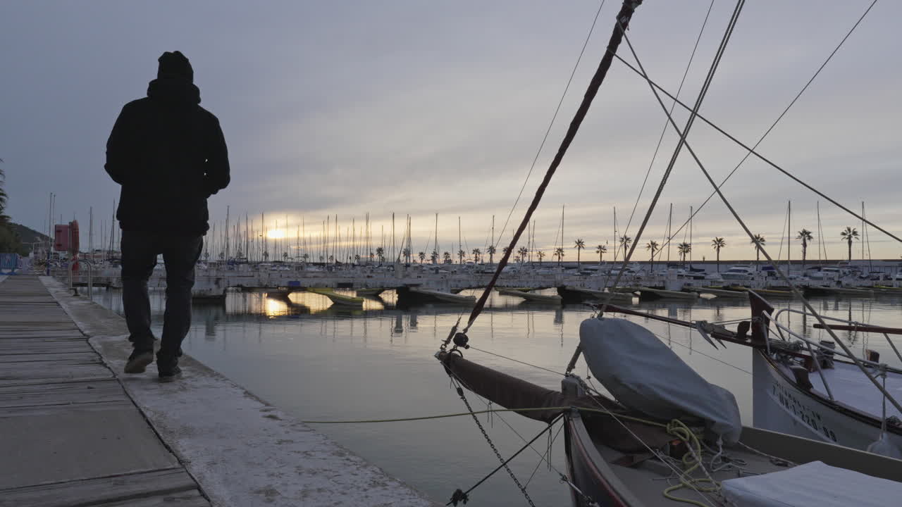 Man takes photo of docked boats in harbor during dusky weather, static shot port