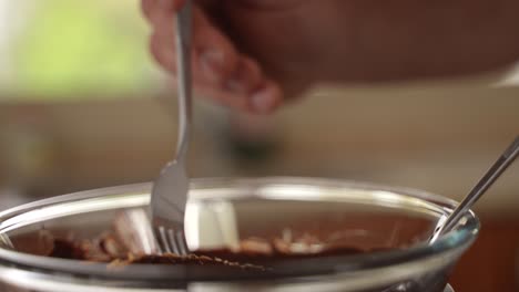 chef dips homemade oatmeal protein bar in molten chocolate, slow motion close up