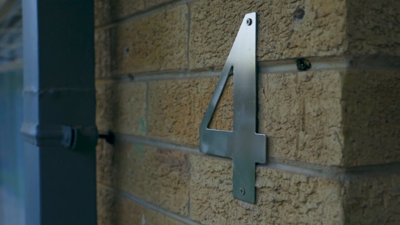 superficie de tipografía de piedra de texto el número cuatro en la pared de la casa utilizada como identificación