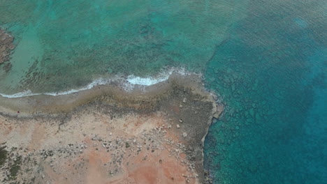 Toma-Aérea-De-Arriba-Hacia-Abajo-De-Agua-De-Mar-Cristalina-Con-Rocas-Bajo-El-Agua-En-Ayia-Napa