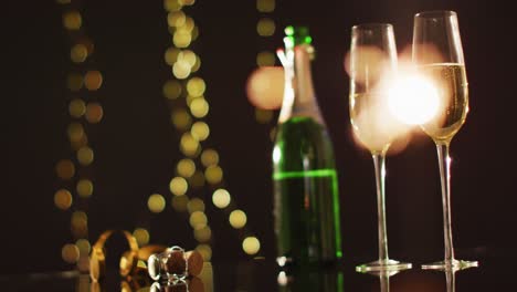 champagne glasses and decorations on black background at new year's eve