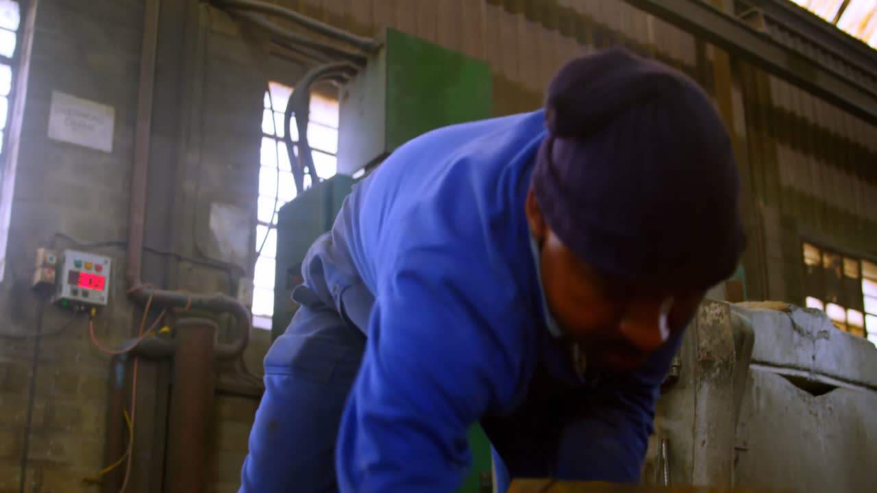 주조 공장에서 금속 조각을 수집하는 노동자 4k