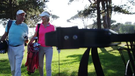 dos golfistas caminando juntos con una bolsa de golf
