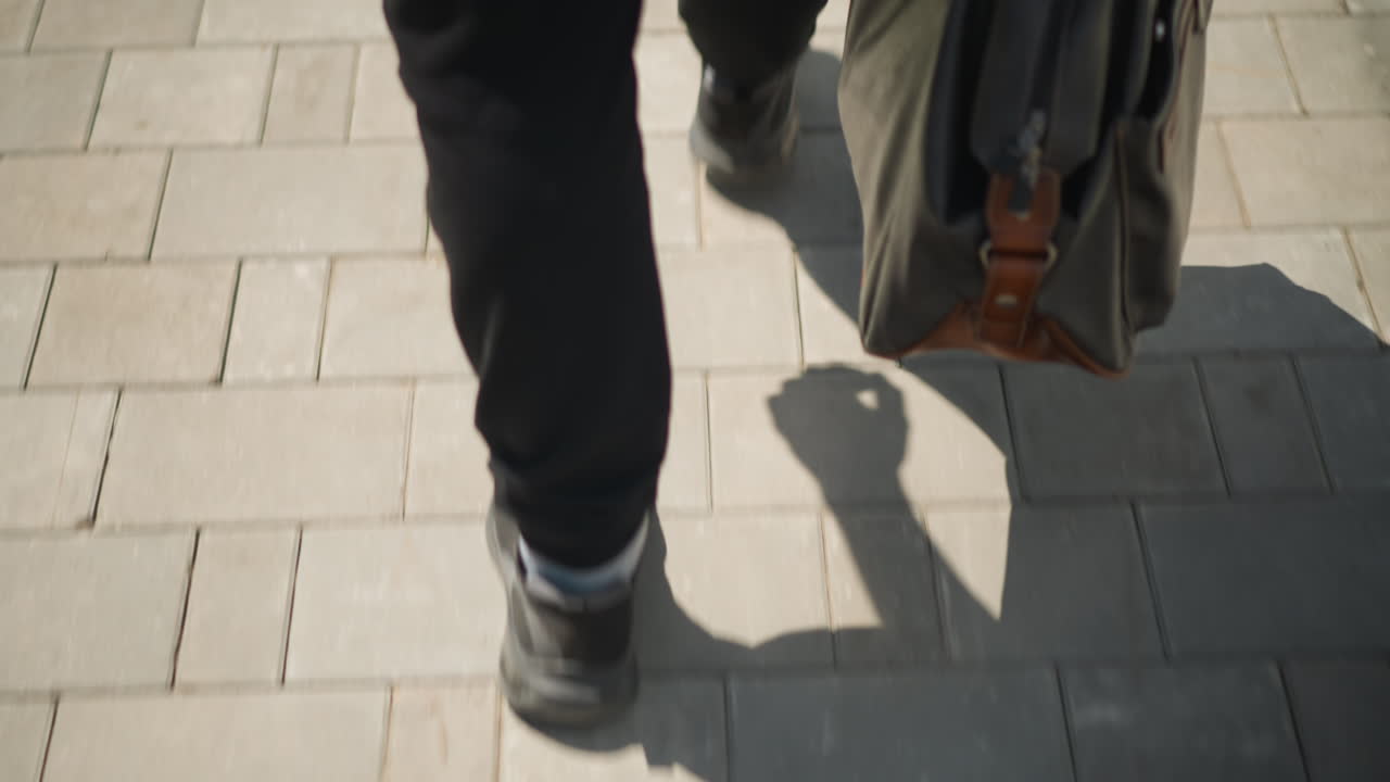 都会の店先近くで足並みをそろえる、店を一緒に歩く2人のクローズアップ、賑やかな街の歩道に沿ってバッグを持って調和して移動する2人の友人または同僚