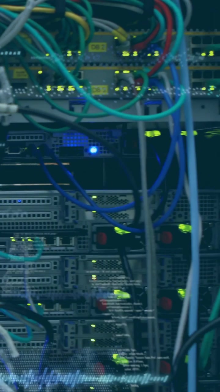 Vertical video: Camera panning right past network rack showing cables, blinking LEDs, telemetry