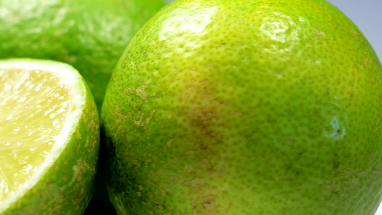 una rebanada de limón verde está girando lentamente en el estudio con los detalles.
